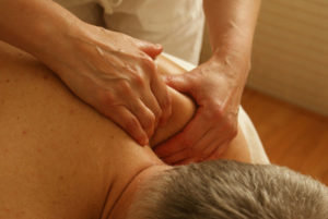 Masseur relaxant l'épaule d'un homme